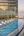 a pool with chairs on the edge of a building