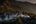a mountain range with tents and smoke