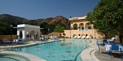 a swimming pool with chairs and a building