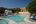 a swimming pool with chairs and a building