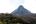 a mountain with trees and clouds