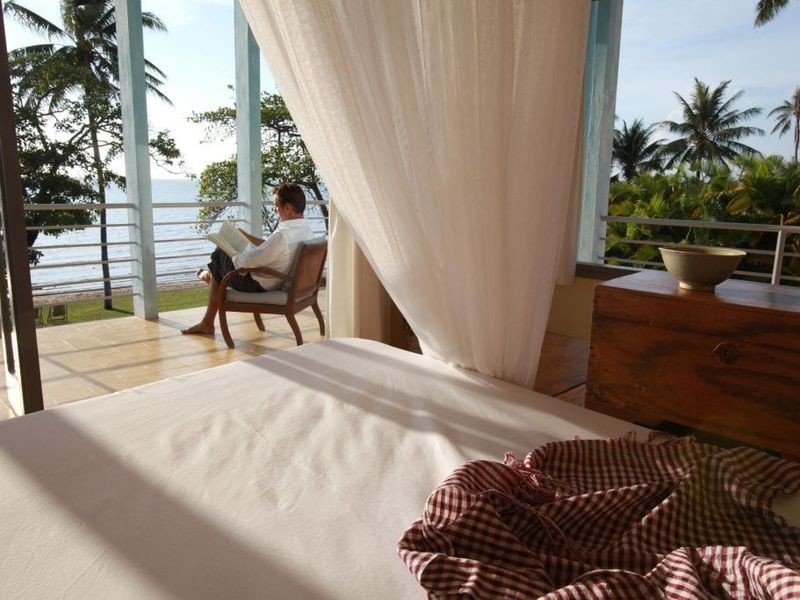 Bedroom with window overlooking the sea at Knai Bang Chatt