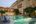 a pool with chairs and tables in front of a building