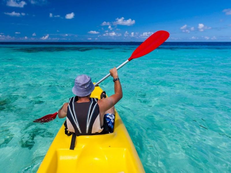 Man kayaking on a blue sea