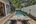 a pool with lounge chairs and a house with trees