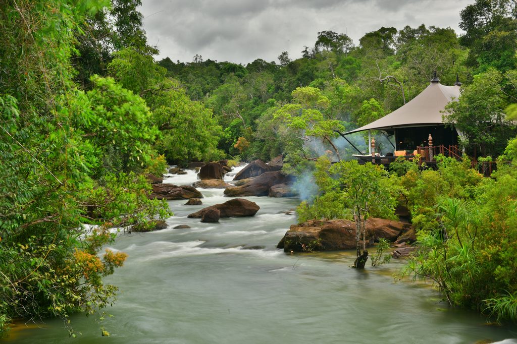 a river with a tent and trees