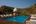 a pool with a gazebo and chairs on a deck