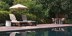 a pool with chairs and umbrella