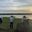 a group of people standing on a rock by a lake