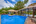 a pool with a thatched roof and a building