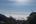 a view of clouds and mountains from a hill
