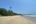 a sandy beach with trees and waves with Alappuzha Beach in the background