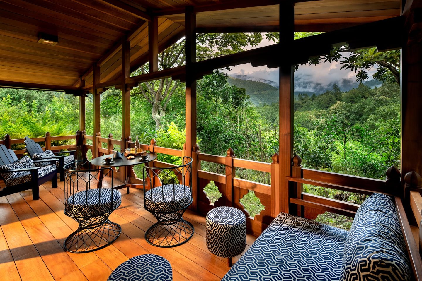 Sofas on a sheltered terrace with forest views at and Beyond Punakha River Lodge