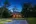 a house with a thatched roof and a pool in the middle of it
