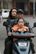 a man and woman riding a scooter