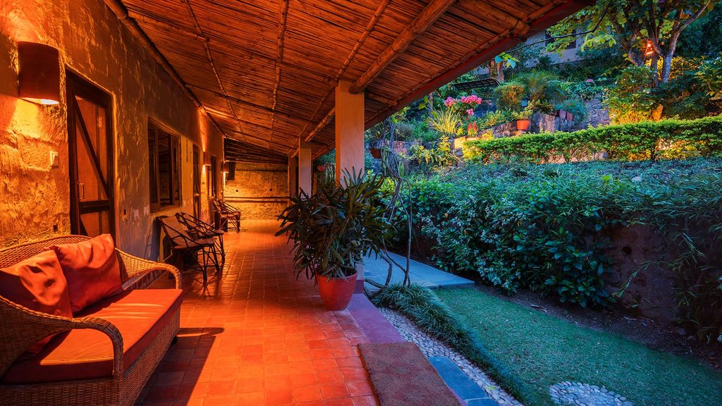 Wicker sofas under a bamboo roof on the terrace at Summit River Lodge