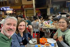 a group of people sitting at a table with food
