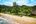 a beach with trees and a building