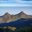 a mountain range with trees and blue sky