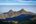 a mountain range with trees and blue sky
