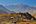 a village on a hill with mountains in the background