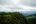 a green hills with trees and clouds