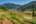 a farm with a river and mountains in the background