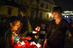 a woman looking at a basket of red lanterns