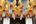 a group of yellow lanterns with ribbons from the ceiling