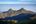 a mountain range with trees and blue sky