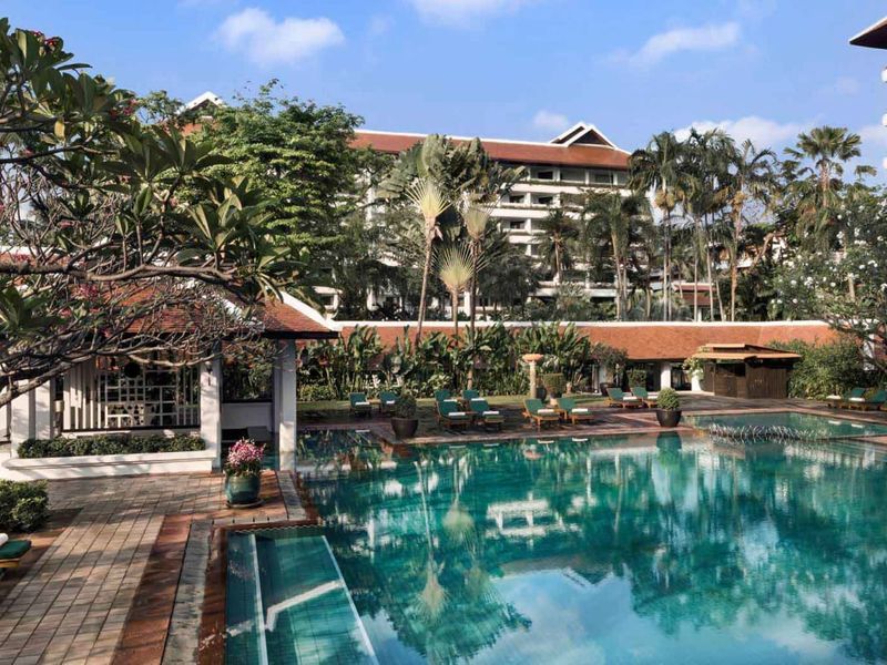 Pool with palm trees at Anantara Riverside