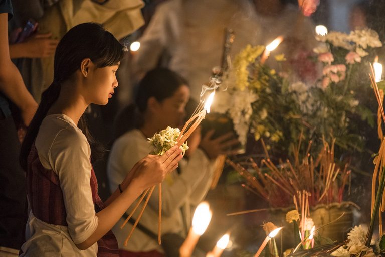 a woman holding flowers and candles