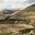 a landscape of a mountain with a road and trees