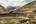 a landscape of a mountain with a road and trees