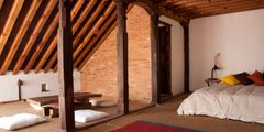a bedroom with a brick wall and a bed
