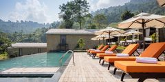 a pool with chairs and umbrellas