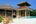 a house with a pool and a thatched roof