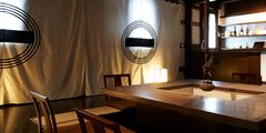 a room with a large rectangular table and a white curtain