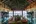 a room with a table and glass walls and a thatched roof