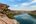 a river with a cliff and trees