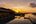 a pool with a body of water and a sunset