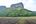 a field with a mountain in the background