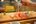 a person holding chopsticks over sushi