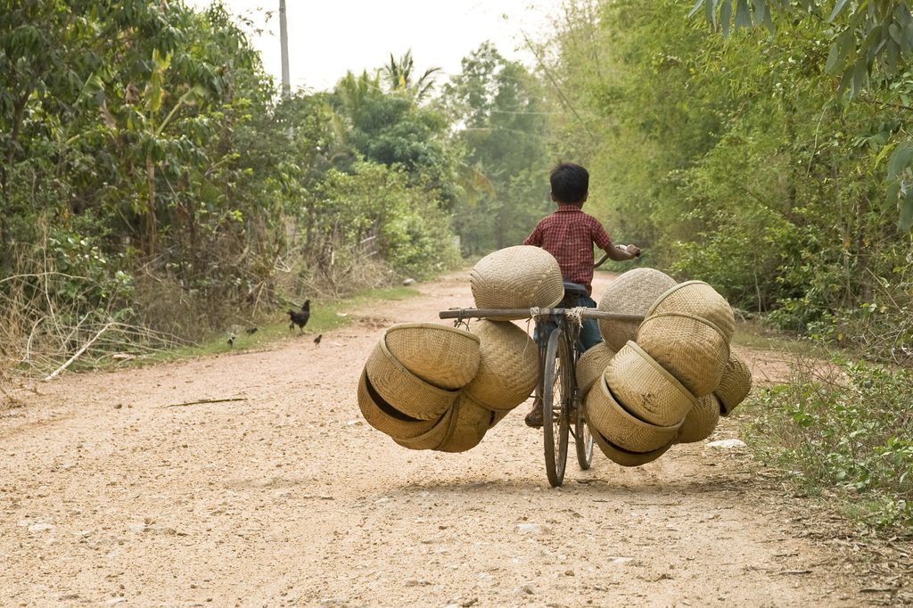 a boy riding a bicycle with baskets on it