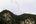 a group of birds flying over a mountain