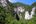a large mountain with trees and a cave