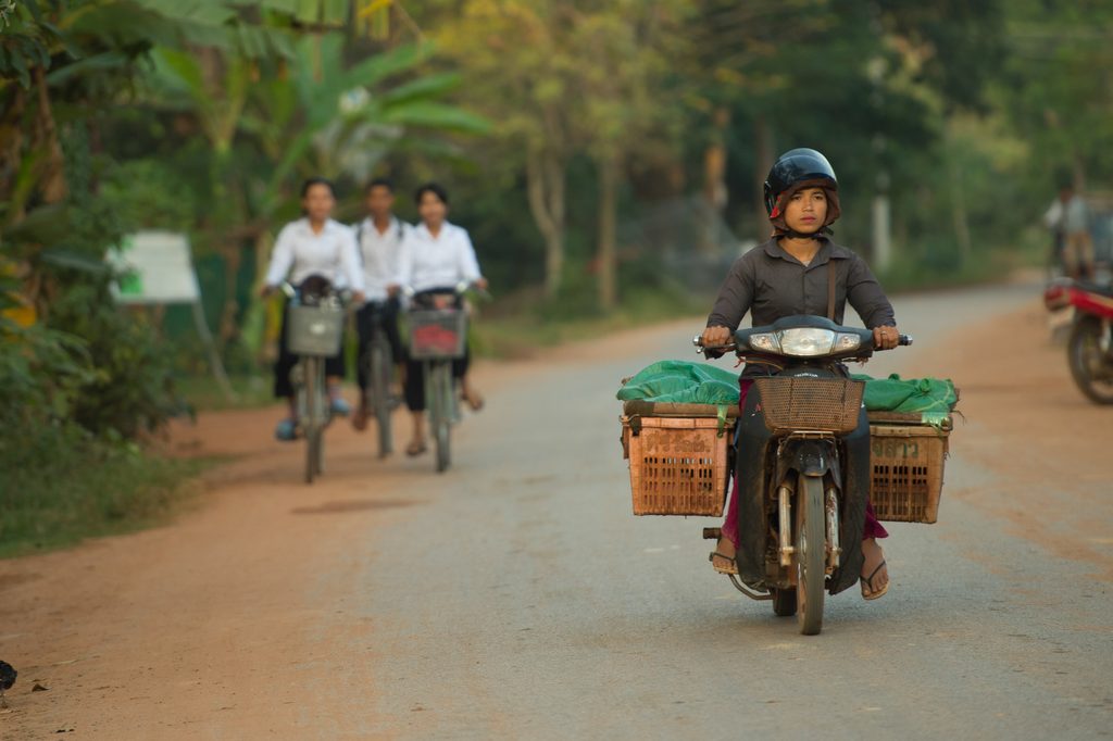 a group of people riding bikes on a road