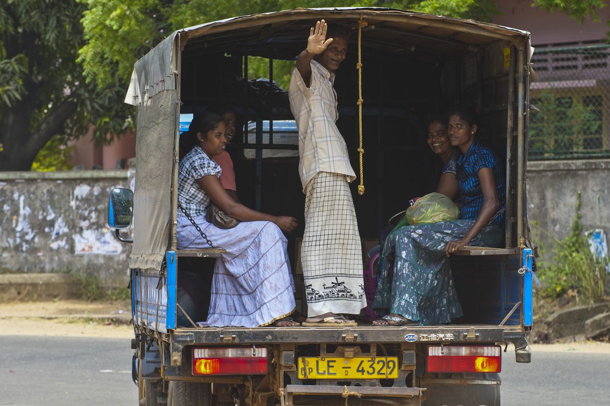 People waving from a van in Sri Lanka