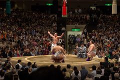 a group of men performing wrestling in a large crowd