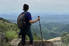 a woman standing on a rock looking at a valley